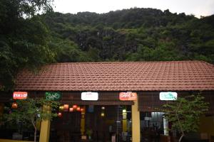 Ein Gebäude mit Dach, im Hintergrund ein Berg in der Unterkunft Trang An Ecorest Resort & Spa in Xuân Sơn