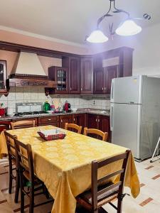 a kitchen with a table and a white refrigerator at Villino Emma in Santadi +7 photos