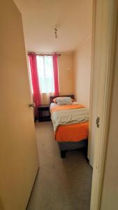 a small room with two beds and a window at Depto Valparaiso in Temuco +5 photos