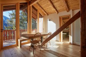 a dining room with a table and chairs and a balcony at Lioda Oak Alpine Charm in Vinigo