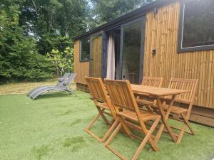 a picnic table and two chairs on a lawn next to a cabin at Cabane des Catalpas in Vollore-Ville