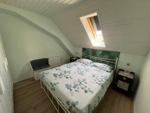 a bedroom with a bed and a window in a attic at La mansardina in Lörrach