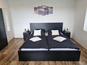 a black bed with two pillows on it in a bedroom at CJS Apartments - Chill or Drive am Nürburgring, Free Parking, WLan, Spacious Rooms, Quiet Location in Rodder