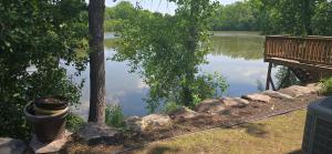 a view of a lake with a bench and some rocks at Lakeview Private Room in St Paul in Little Canada