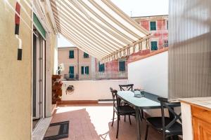 Un patio con una mesa y sillas en un balcón. en Luna House, en La Spezia
