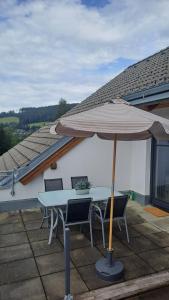 a table and chairs with an umbrella on a patio at Ski, bike, hike & chill! in Sankt Kathrein am Hauenstein