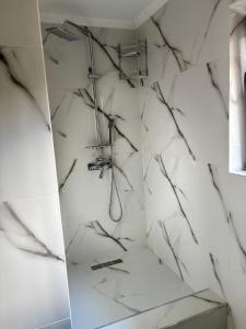 a bathroom with a shower with white marble walls at Casa Lazar in Cumpăna +50 photos