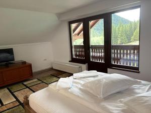 a bedroom with a bed and a large window at Casa Lazar in Cumpăna
