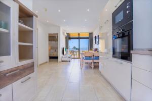 eine Küche mit weißen Schränken und ein Esszimmer in der Unterkunft Luxury Los Cactus in San Bartolomé de Tirajana