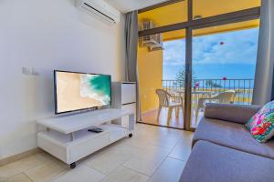 ein Wohnzimmer mit Fernseher und Sofa in der Unterkunft Luxury Los Cactus in San Bartolomé de Tirajana