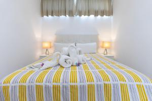 ein Schlafzimmer mit einem Bett mit zwei Stofftieren darauf in der Unterkunft Luxury Los Cactus in San Bartolomé de Tirajana + 28 Fotos