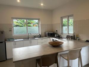 a kitchen with a large island in the middle of it at Maison Marie Jeanne - Unit 1 in Baie Sainte Anne