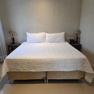 a large bed with white sheets and pillows on it at Zielo Hotel in Asuncion