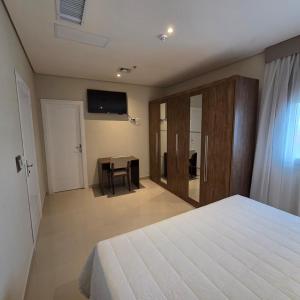 a bedroom with a bed and a table and a television at Zielo Hotel in Asuncion