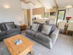 a living room with two couches and a coffee table at Springtime Lodge in Abergele