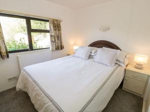 a bedroom with a large white bed with two pillows at Springtime Lodge in Abergele