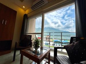 a living room with a large window with a view of the ocean at Hotel Uday Palace in Rishīkesh