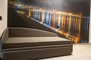 1 cama en una habitación con una pintura de un río en Lolli Boutique & SPA Mondello, en Palermo