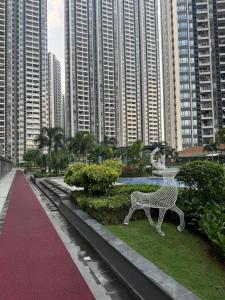 a sculpture of a deer in a park with tall buildings at R&F Princess Cove Swimming View By TGW STUDIO in Johor Bahru