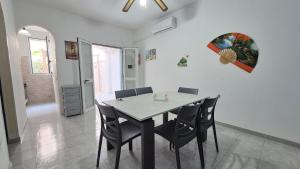 a dining room with a table and chairs at Appartamento Mozart 3 a Pescoluse in Marina di Pescoluse