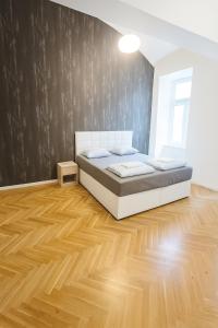 a bedroom with a bed and a wooden floor at Life Style Appartment 1 in Vienna
