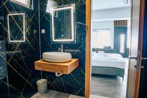 a bathroom with a sink and a mirror and a bed at Hotel Nur in Mostar