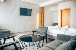 a hotel room with a bed and a couch and a table at Hotel Nur in Mostar +32 photos