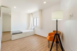a bedroom with a bed and a chair and a mirror at Bright 2BDR Flat in Armação de Pêra by LovelyStay in Armação de Pêra