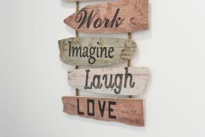 a group of reclaimed wood signs with the words moms imagine love at Bright 2BDR Flat in Armação de Pêra by LovelyStay in Armação de Pêra