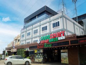 a white car parked in front of a building at Bona Ventura Hotel & Skybar in Tanjung Pinang