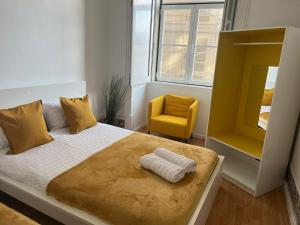 a bedroom with a large bed with a yellow chair at Luxury rooms in the centre of Lisbon, Alfama in Lisbon +20 photos