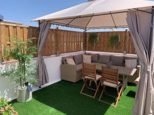 a patio with a table and chairs under a tent at Apartamento Sotavento - 2 dormitorios in Chipiona