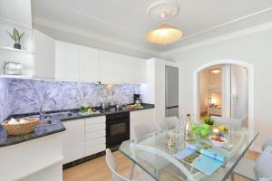 a kitchen with a glass table and white cabinets at Casa Nena by VillaGranCanaria in Playa del Ingles