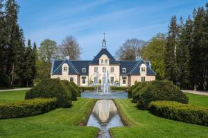 an exterior view of a large house with a fountain at Trevlig lägenhet på Bjärehalvön in Lillaryd