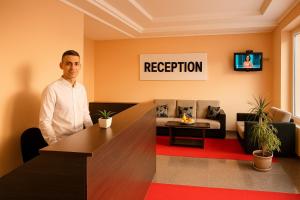 a man standing in a room with a reception desk at Apartments Contessa in Ulcinj