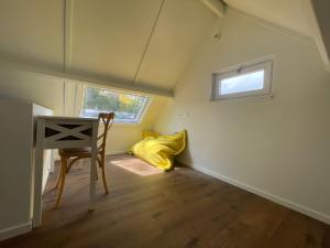 una stanza con una scrivania e un cuscino giallo di Chocolat & Vanille a Koksijde