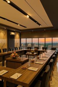 a large dining room with tables and chairs and windows at Bona Ventura Hotel & Skybar in Tanjung Pinang 