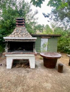 a outdoor fireplace with a bench next to a house at Koti Mountain House in Litochoro