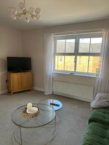 a living room with a glass table and a tv at 2 bed apartment Moulton Park in Spinney Hill
