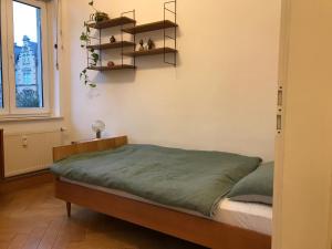 a bedroom with a bed and shelves on the wall at Stylische Mid-Century-Wohnung im Zentrum Plauens in Plauen
