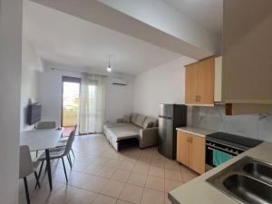 une cuisine et un salon avec un canapé et une table dans l'établissement Reys Central Orikum 2-Bedroom Apartment for Five, à Polisi i Vogël