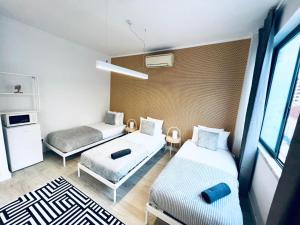 Habitación pequeña con 2 camas y sofá en Luxury rooms best location of Lisbon, next attractions, en Lisboa