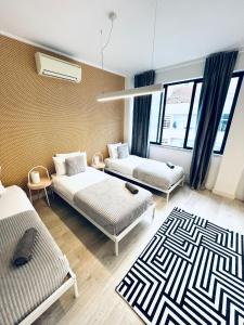 una habitación con dos camas y un sofá en Luxury rooms best location of Lisbon, next attractions, en Lisboa