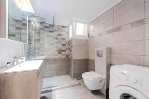 a bathroom with a toilet and a sink and a washing machine at Sonia's Maison in Limenas +13 photos