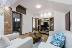 a living room with a white couch and a table at Sonia's Maison in Limenas