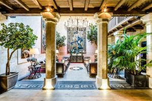 un vestíbulo con plantas y una lámpara de araña en Grand Hotel Don Gregorio en Salamanca