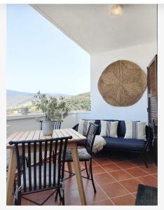Un comedor con una mesa y sillas y un sofá. en El Refugio de Alcolea, Alpujarra Almeriense, en Alcolea