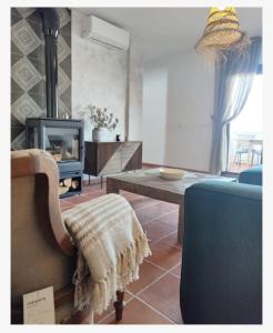 Una sala de estar con un sofá y un televisor. en El Refugio de Alcolea, Alpujarra Almeriense, en Alcolea