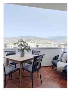 Una mesa y sillas en un balcón con una mesa. en El Refugio de Alcolea, Alpujarra Almeriense, en Alcolea