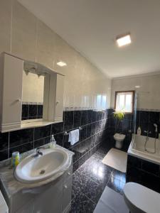 a bathroom with a sink and a toilet at Casa do Senhor da Ponte in Gondifelos